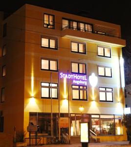 a building with a sign on the front of it at Stadthotel Augsburg in Augsburg