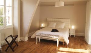 a bedroom with a white bed with two lamps and two tables at Le château de la brosse Chambres d'hôtes in Brinay