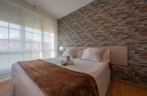 un bebé sentado en una cama en un dormitorio en Hotel Ancora Urban Center en Finisterre