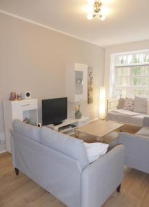 sala de estar con sofá y TV en App. Weisses Haus, en Hohen Neuendorf