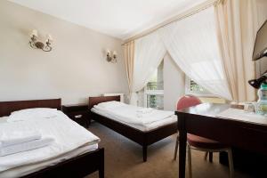 a room with two beds and a desk and a window at Pokoje w Portofino in Lublin