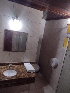 a bathroom with a sink and a toilet at Pousada do Forte in Barra do Cunhau