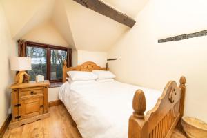 a bedroom with a bed and a window at Nant Ucha Farm Holiday Cottages near Llangollen in Acrefair