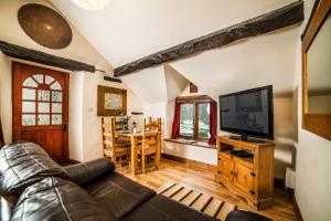 a living room with a couch and a television at Nant Ucha Farm in Acrefair