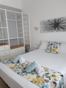 1 dormitorio con 1 cama con toallas en Garbí & Xaloc apartamentos, en Cala Galdana