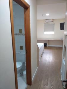a bathroom with a toilet and a bed in a room at Hotel Hetropolis in São Bernardo do Campo