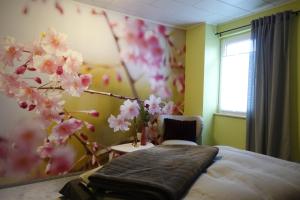 a bedroom with a bed and a tree with pink flowers at Ferienwohnung Landidyll in Saalburg