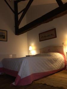 um quarto com uma cama grande num quarto em chambre dans Prieuré de caractère XVIII siècle em Planioles