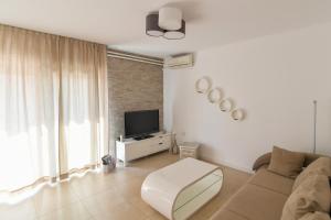 a living room with a couch and a tv at Apartment Amelie in Opatija