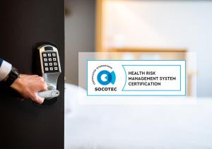 a person holding a door handle with ahealth risk management system certification sign at B&B HOTEL Antwerpen Zuid in Antwerp