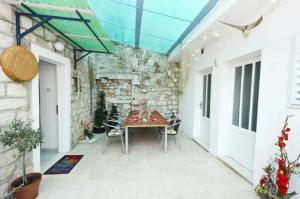 a patio with a table and chairs and a stone wall at Villa Marini dvori in Trogir
