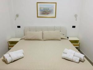 1 cama grande con 2 almohadas encima en Hotel Marittima en Rímini