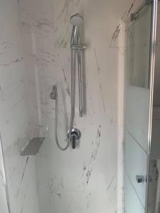 W łazience z białymi marmurowymi ścianami znajduje się prysznic. w obiekcie Hotel Marittima w Rimini