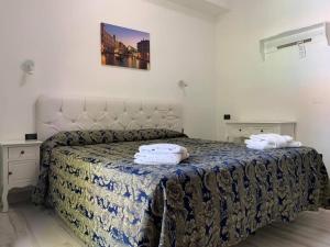 a bedroom with a bed with two towels on it at Hotel Marittima in Rimini