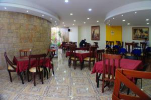 a restaurant with tables and chairs and a brick wall at Hotel Santa Isabel 2 in Ipiales