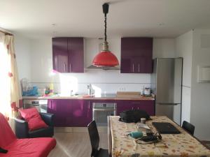 a kitchen with purple cabinets and a table with a laptop on it at Apartamento T28 Edif Europa y parking gratuito in Sierra Nevada