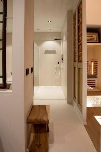 een badkamer met een inloopdouche en een houten bank bij Wabi Sabi B&B in Peer
