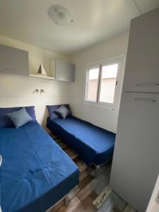 Habitación pequeña con 2 camas y ventana en CAMPING LA BREVA, en Dongo