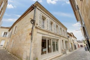 un viejo edificio en una calle en una ciudad en Badon Boutique Hotel, en Saint-Émilion