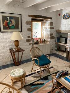 a living room with a chair and a table at Maison près de l'Océan in Pont-Croix