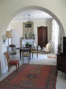 een boog in een woonkamer met een tafel en stoelen bij Cottage Massanet in Grasse