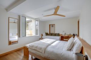 Schlafzimmer mit einem Bett und einem Deckenventilator in der Unterkunft Badon Boutique Hotel in Saint-Émilion