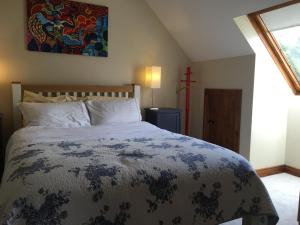 Eden Cottage Countryside Retreat في اينيس: غرفة نوم بسرير وصالب على الحائط