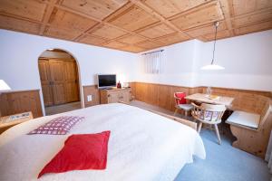 a bedroom with a large white bed and a table at Hotel Engiadina in Scuol