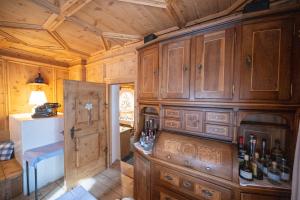 a kitchen with wooden cabinets and a counter with wine bottles at Hotel Garni Engiadina - Boutique Hotel in Scuol