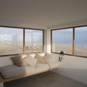 a couch sitting in a room with windows at Coastguard Lookout by Bloom Stays in Littlestone-on-Sea