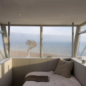 a room with a couch in front of a window at Coastguard Lookout by Bloom Stays in Littlestone-on-Sea