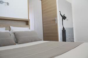 Un dormitorio con una cama y una puerta con una bailarina. en MOTEL ASCOT - Hotel & Appartements, en Cagnes-sur-Mer