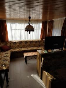 a living room with a couch and a window at ferme pedagogique des pennetieres in Montcorbon