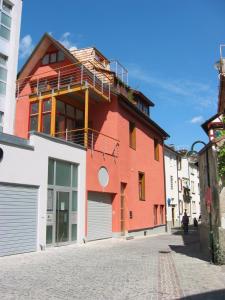 ein rotes Gebäude mit Balkon auf einer Straße in der Unterkunft beliebtes City-Apartment Reutlingen in Reutlingen