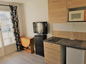 a kitchen with a black refrigerator and a microwave at YELETIM in Courseulles-sur-Mer