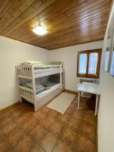 ein kleines Zimmer mit einem Etagenbett und einem Tisch in der Unterkunft Cal Masuret in Planoles