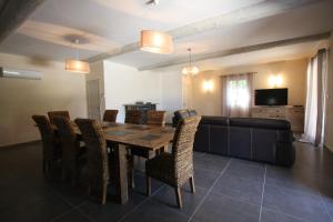 a dining room with a table and chairs and a couch at maison 180 m² proche de Beaumes de Venise in La Roque-Alric