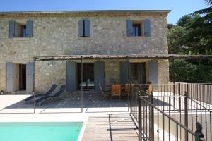 a stone house with a pool in front of it at maison 180 m² proche de Beaumes de Venise in La Roque-Alric