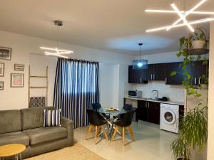 ein Wohnzimmer und eine Küche mit einem Sofa und einem Tisch in der Unterkunft Fat Cow Apartment 103 in Larnaka