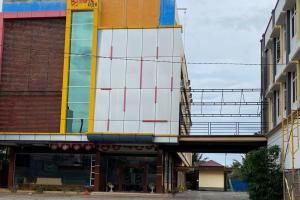 a building with a bridge over a street at RedDoorz Plus Syariah @ Jalan Syiah Kuala Banda Aceh in Lheue