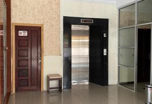 a hallway with a door and a stool in a building at RedDoorz Plus Syariah @ Jalan Syiah Kuala Banda Aceh in Lheue