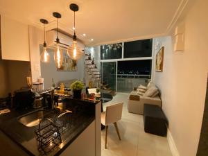 cocina y sala de estar con vistas a la sala de estar en Loft luxo duplex com dois colchões adicionais e sofá cama, en Salvador