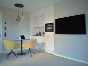 een keuken met een tafel en twee stoelen en een televisie bij Ferienhaus Stadtblick in Bad Marienberg