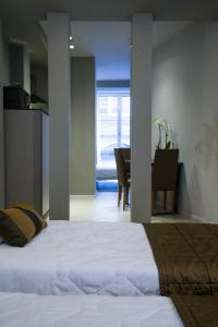 a bedroom with a white bed and a dining room at Appartamenti Astoria in Bologna