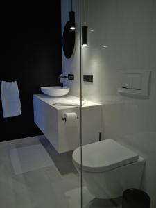 biała łazienka z toaletą i umywalką w obiekcie Ferienhaus Stadtblick w mieście Bad Marienberg