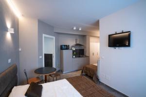 a room with two beds and a table and a kitchen at Appartamenti Astoria in Bologna