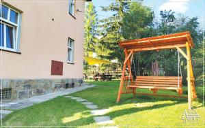 a wooden swing in a yard next to a building at Przystanek Rabka - Apartamenty w centrum in Rabka-Zdrój