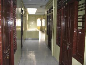 a hallway with wooden doors and a bath room at Vasantha Lodge Purasawalkam chennai in Chennai