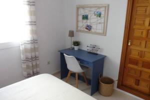 niebieskie biurko z krzesłem w sypialni w obiekcie Apartamento completo max. 6 huéspedes w mieście Cumbre del Sol +34 zdjęcia
