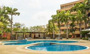 a swimming pool in front of a building at Desarrollo Turístico Punta Brava Tucacas Morrocoy in Tucacas